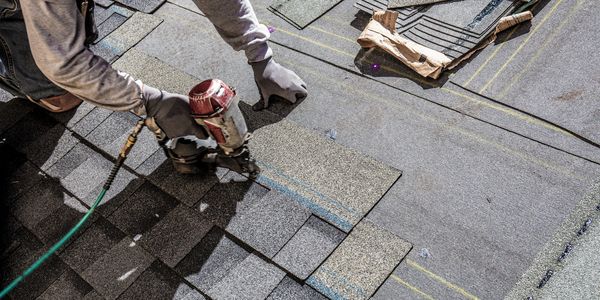 Roofer installing shingles overhead view